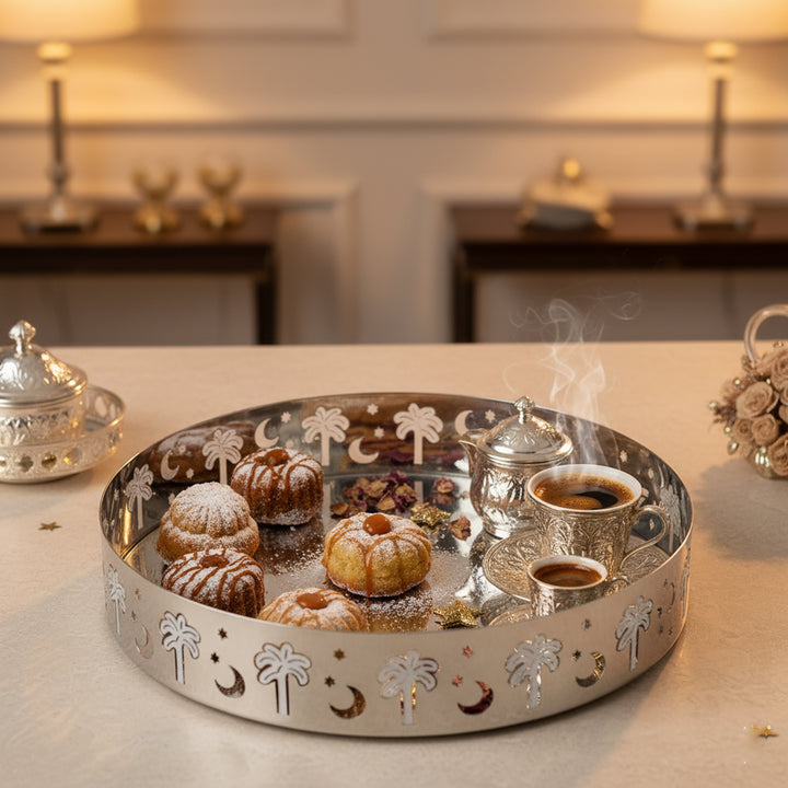 Decorative tray with pastries and teapots on a table with a blurred background