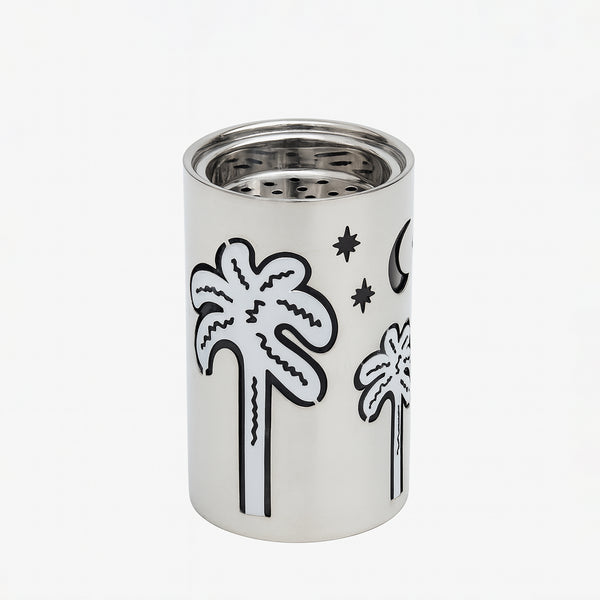 Silver cylindrical container with black palm tree and moon designs on a white background