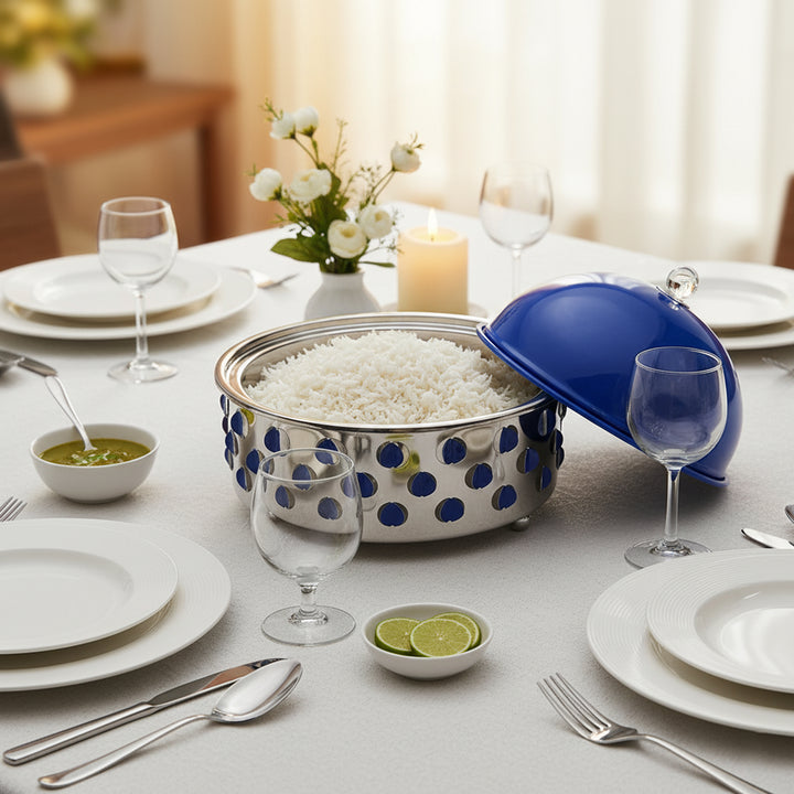 Dining table set with polka dot serving bowl, plates, glasses, and utensils.