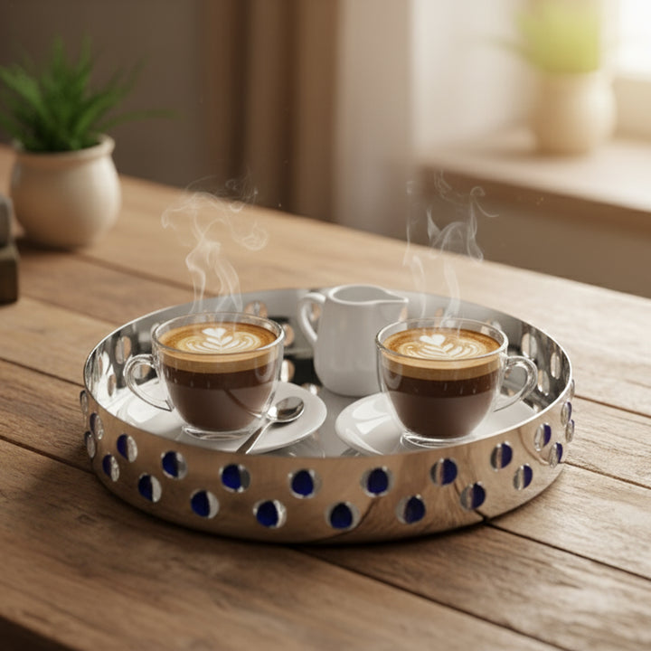 Two steaming cups of coffee on a decorative tray with a blurred indoor background