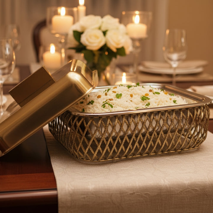 Decorative dish with rice and garnishes on a table setting with candles and flowers.