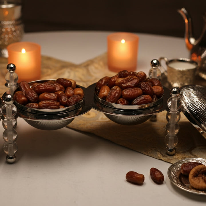 Bowl of dates with candles and a teapot in the background