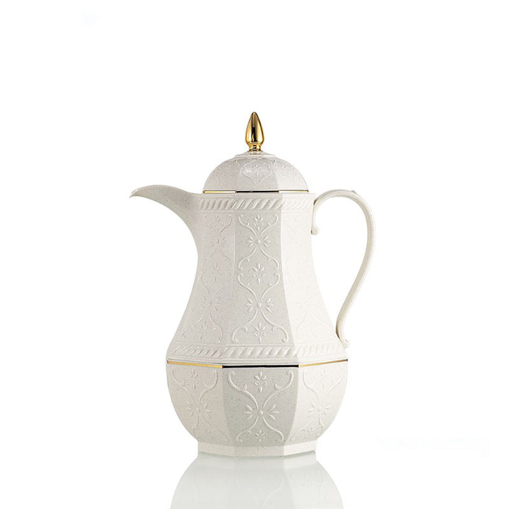 White ceramic coffee pot with gold accents on a white background