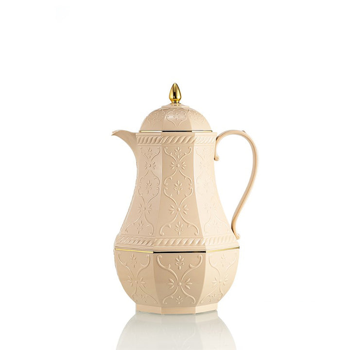Cream-colored coffee pot with gold accents on a white background
