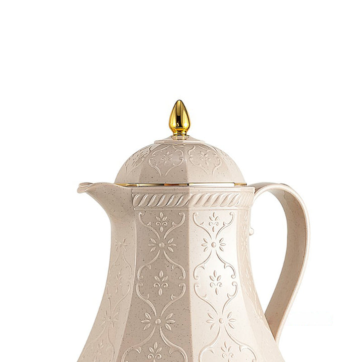 Decorative white coffee pot with gold lid on a white background