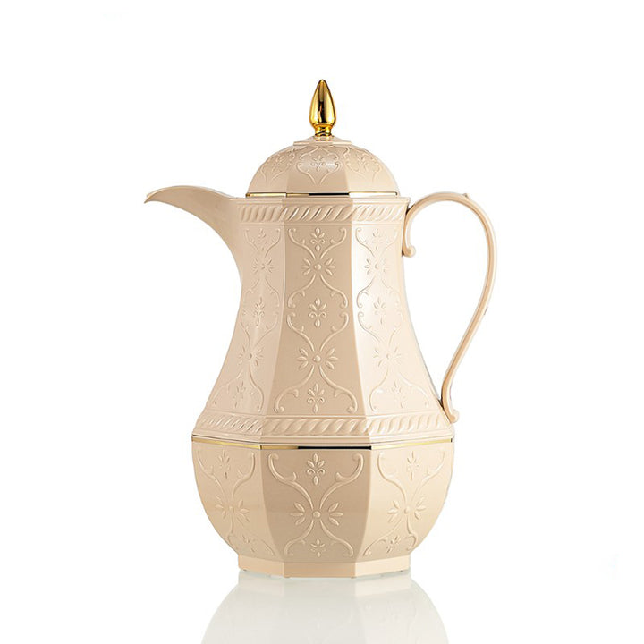 Decorative cream-colored teapot with gold accents on a white background