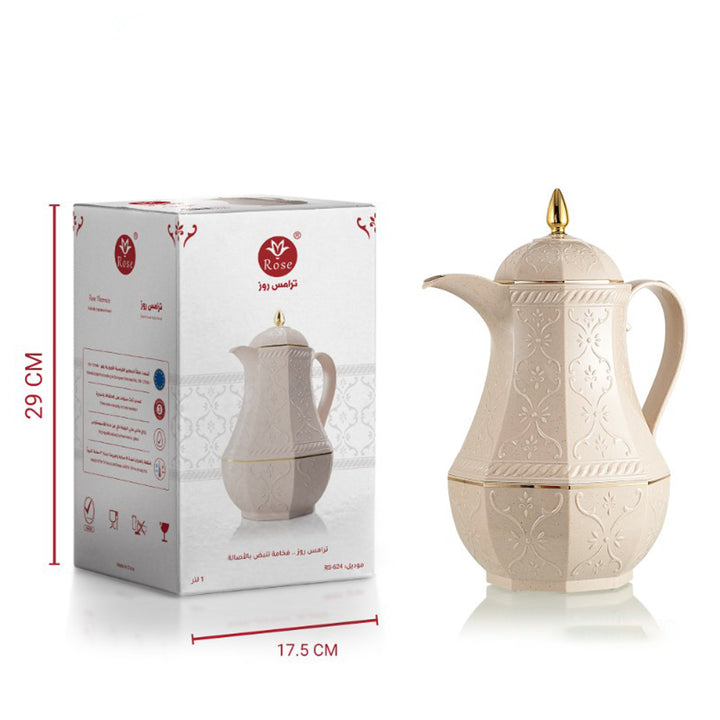 Beige ceramic teapot with gold accents next to its packaging box on a white background
