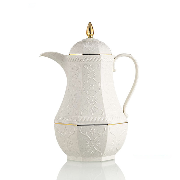 White ceramic coffee pot with gold accents on a white background