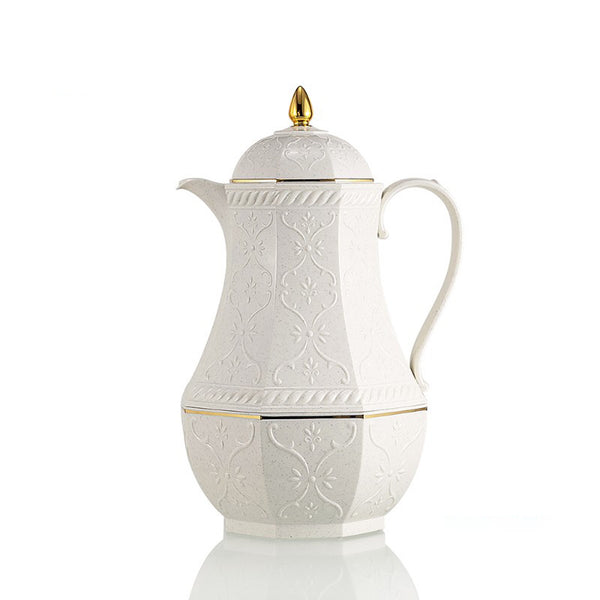 White ceramic coffee pot with gold accents on a white background