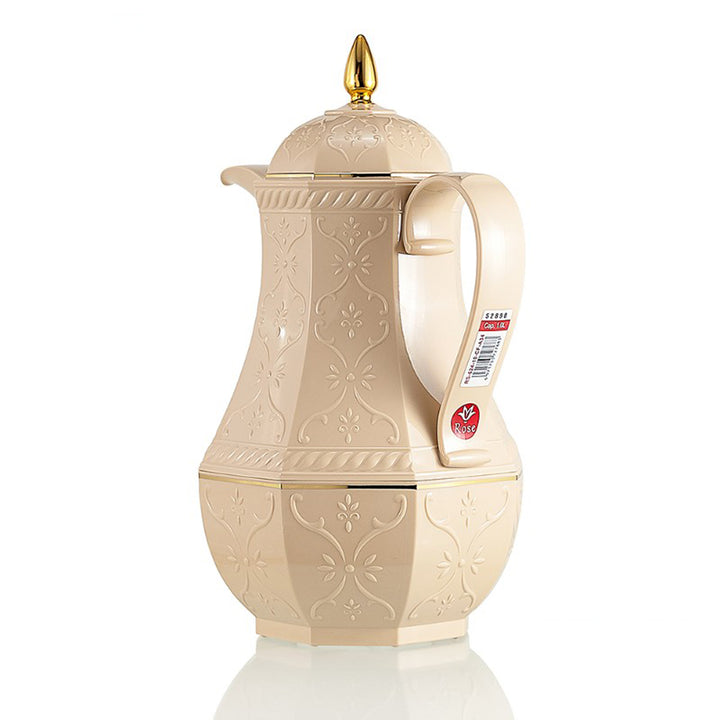 Cream-colored embossed pitcher with a gold spout on a white background