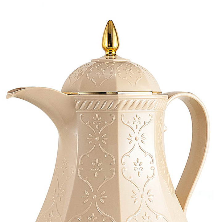 Cream-colored teapot with gold lid on a white background