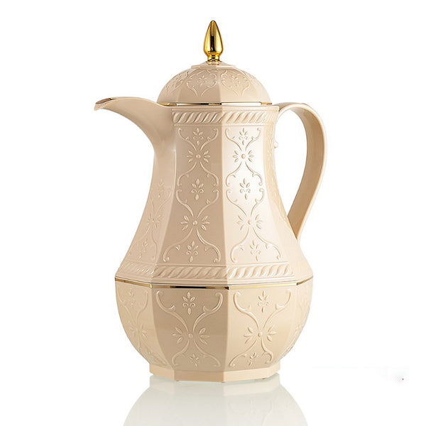 Decorative cream-colored coffee pot with gold accents on a white background