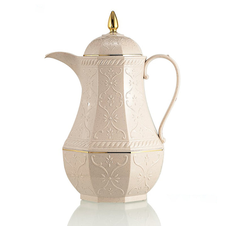 Decorative cream-colored coffee pot with gold accents on a white background