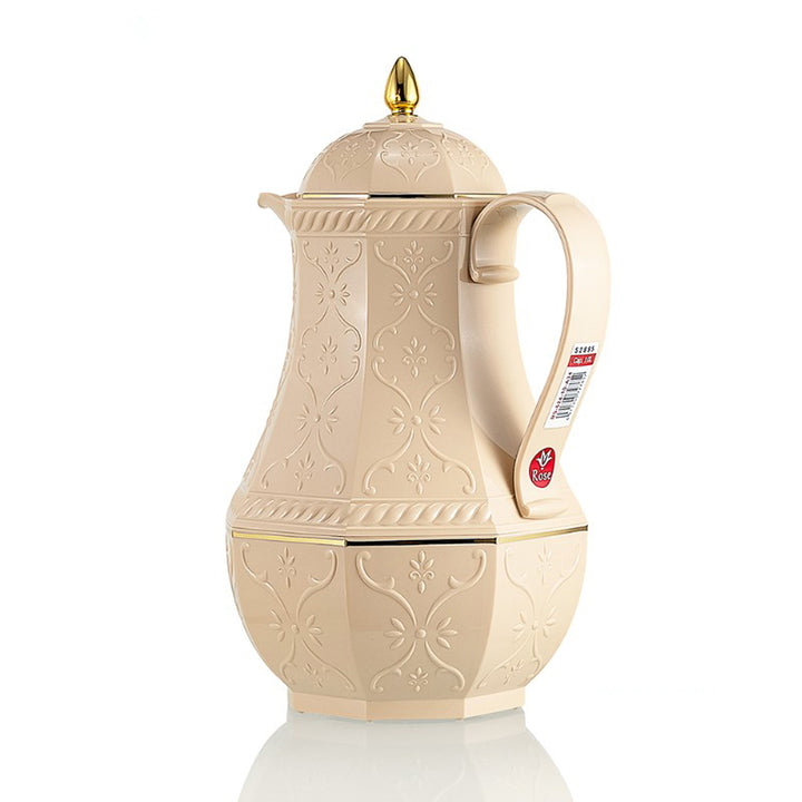 Cream-colored coffee pot with gold accents on a white background