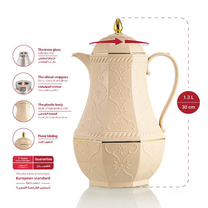Decorative cream-colored teapot with gold accents on a white background