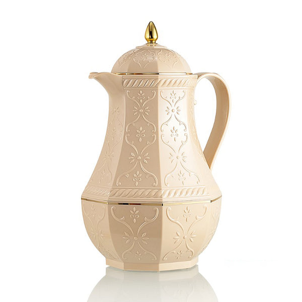 Decorative cream-colored coffee pot with gold accents on a white background