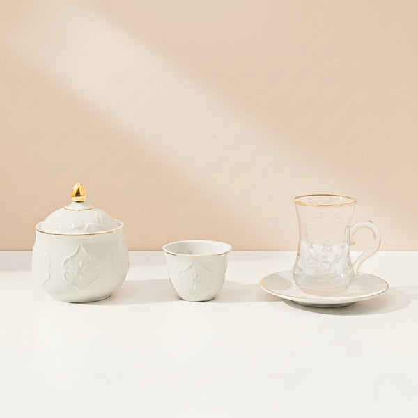 Set of ceramic tea cups and a sugar bowl on a light surface with a beige background