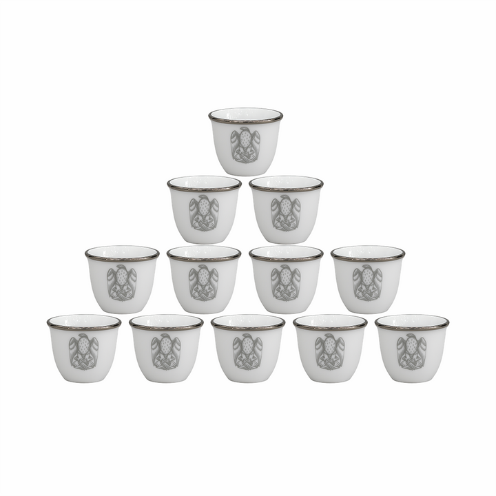 Set of twelve white ceramic cups with decorative patterns on a white background