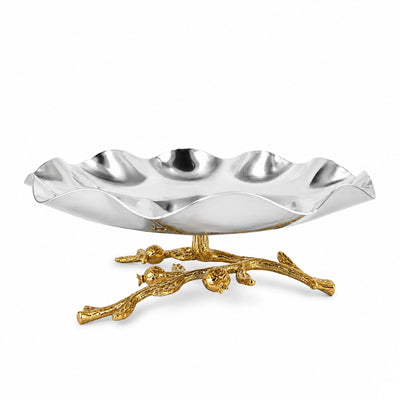 A decorative silver and gold serving tray with a wavy scalloped rim, resting on a branch-like gold pedestal against a plain white background.