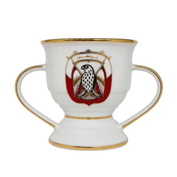 Decorative cup with handles and a central emblem on a white background