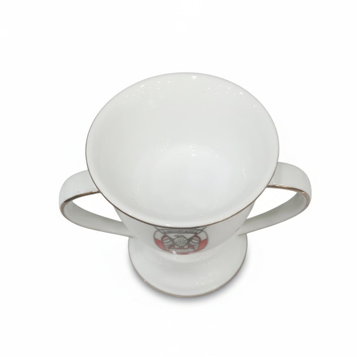 White ceramic cup with a decorative emblem on a white background