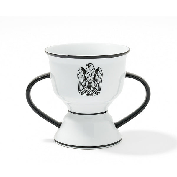 White ceramic cup with black handles and an eagle emblem on a white background