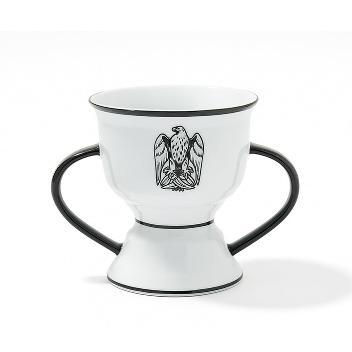 White ceramic cup with black handles and an eagle emblem on a white background