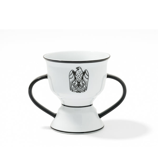 White ceramic cup with black handles and an eagle emblem on a white background
