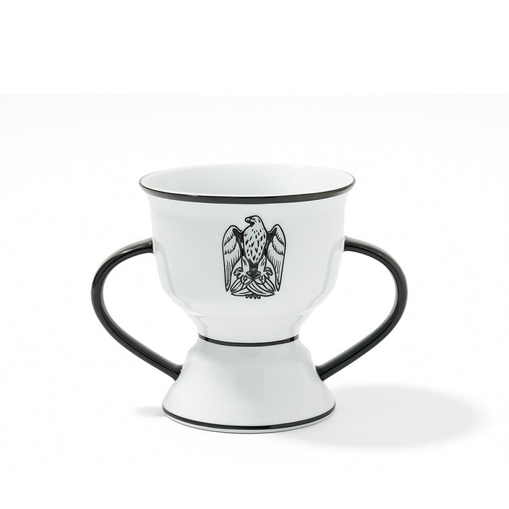 White ceramic cup with black handles and an eagle emblem on a white background