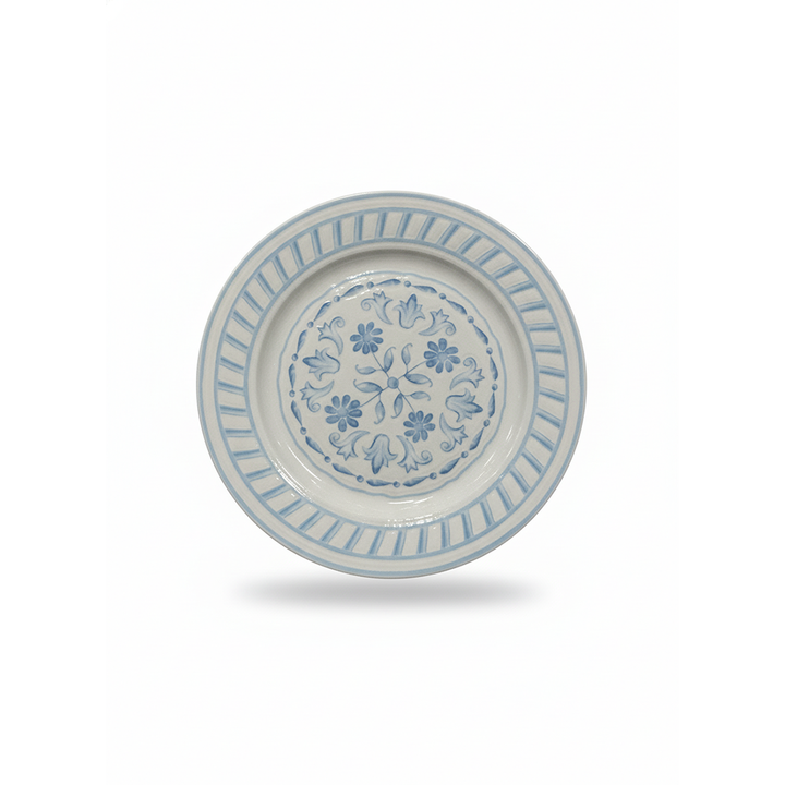 Ceramic plate with floral design and blue decorative elements on a white background