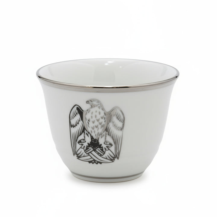 White ceramic cup with black eagle design on a white background