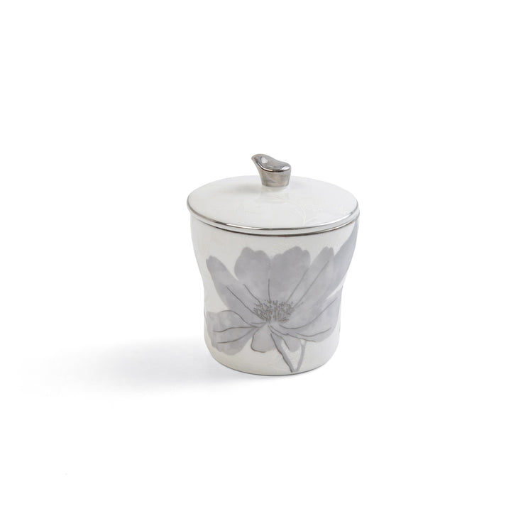 Ceramic sugar bowl with floral design and silver lid on a white background