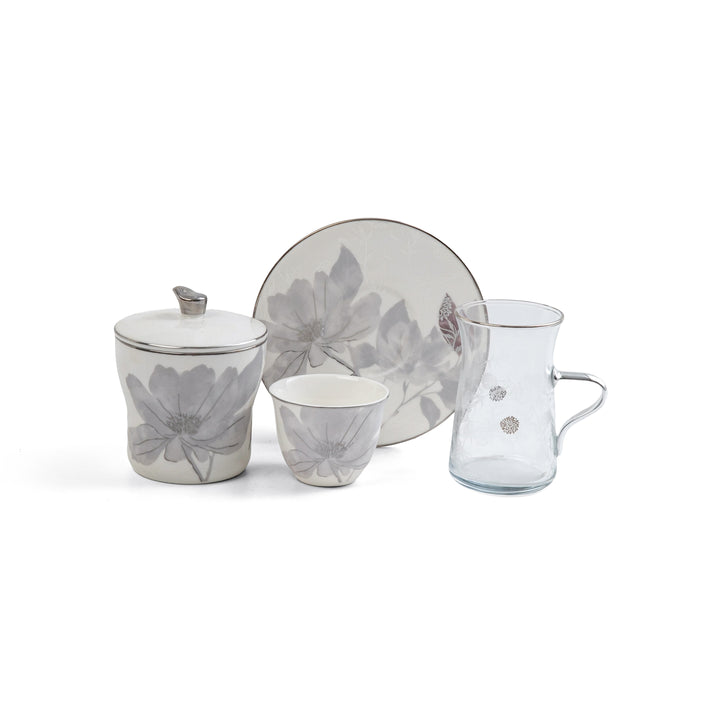 Ceramic tea set with floral design on a white background