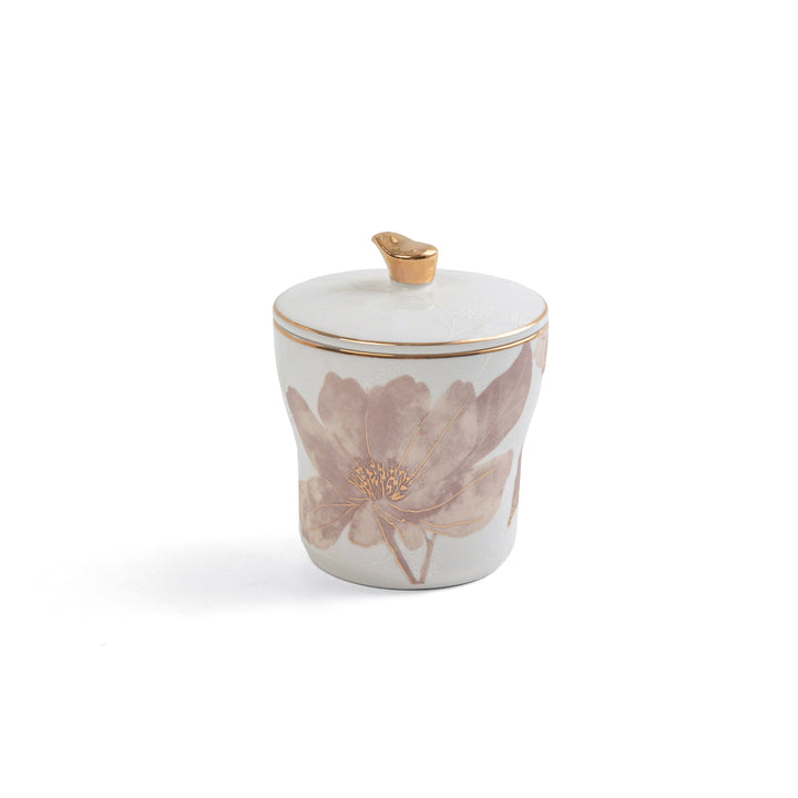 White ceramic jar with floral design and gold accents on a white background