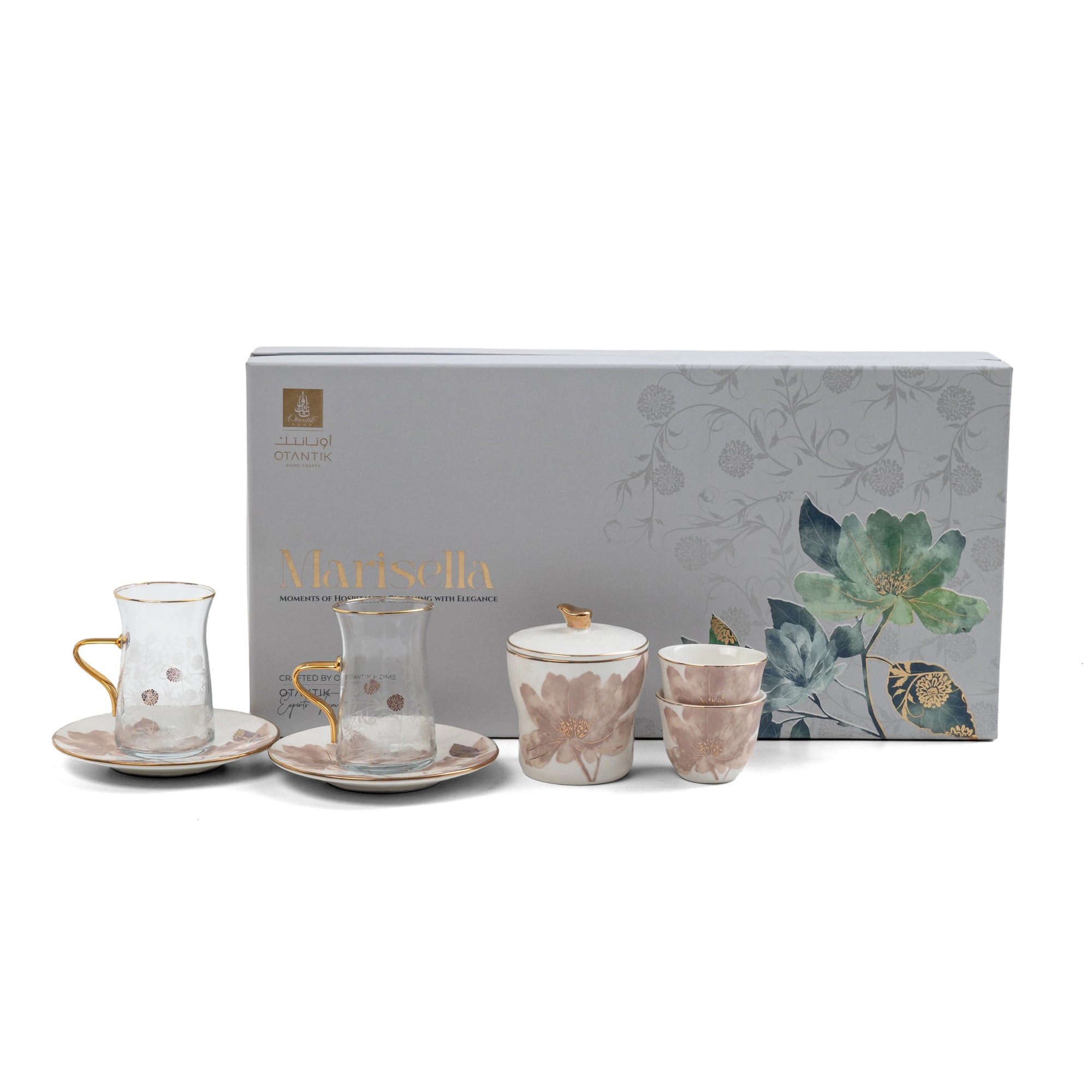 Tea set with floral design in front of a decorative box on a white background