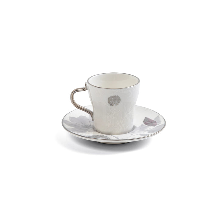 White ceramic cup and saucer with a subtle pattern on a white background