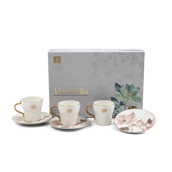 Set of ceramic tea cups and saucers with floral design, displayed in front of a branded box.
