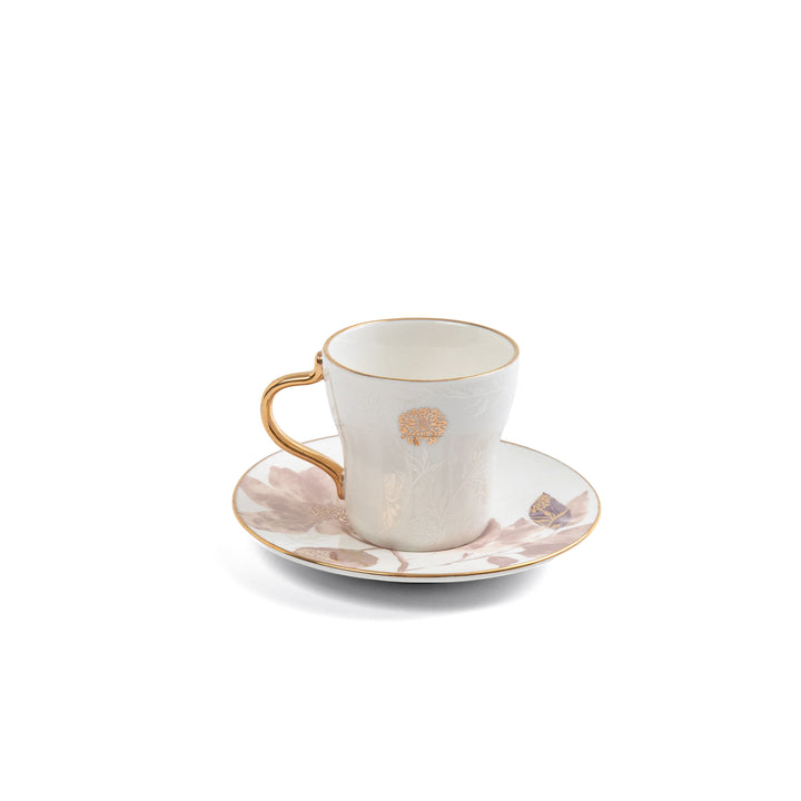 Ceramic cup and saucer set with floral design on a white background