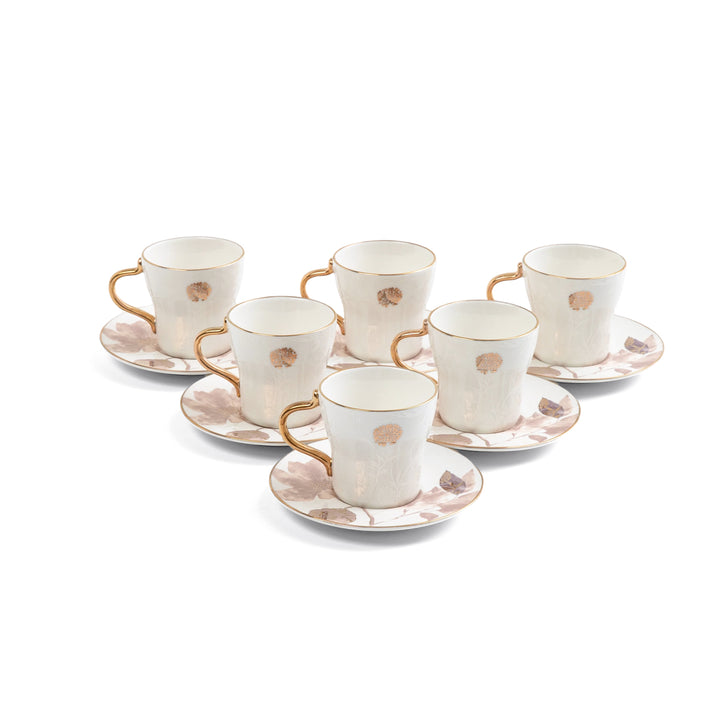 Set of six ceramic cups and saucers with gold accents on a white background