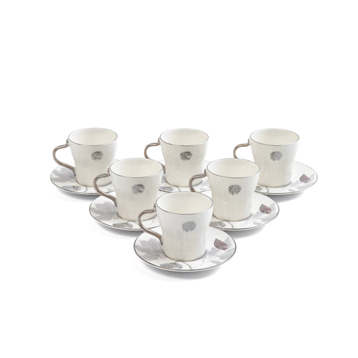 Set of six white ceramic cups and saucers with decorative elements on a white background