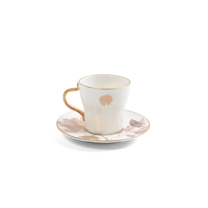 Ceramic cup and saucer with floral design on a white background