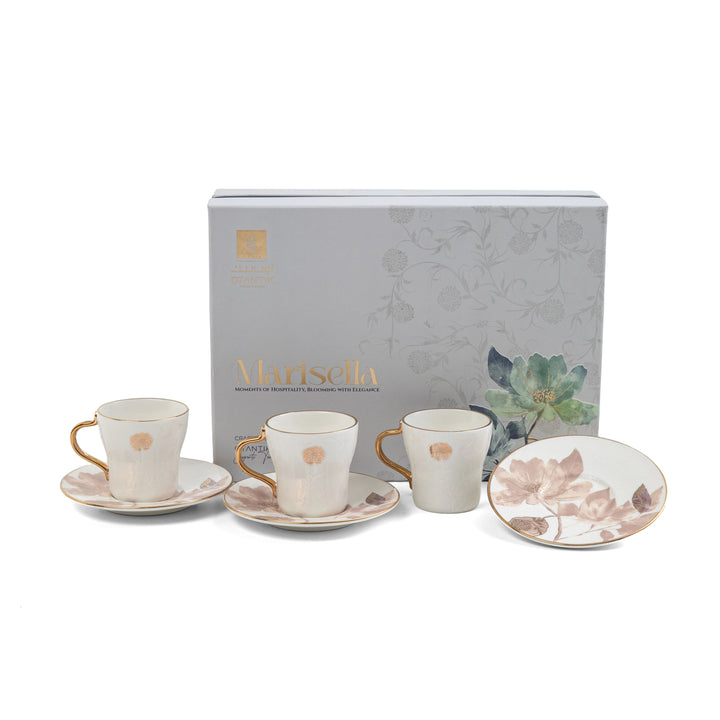 Set of ceramic cups and saucers with floral design in front of a branded box on a white background