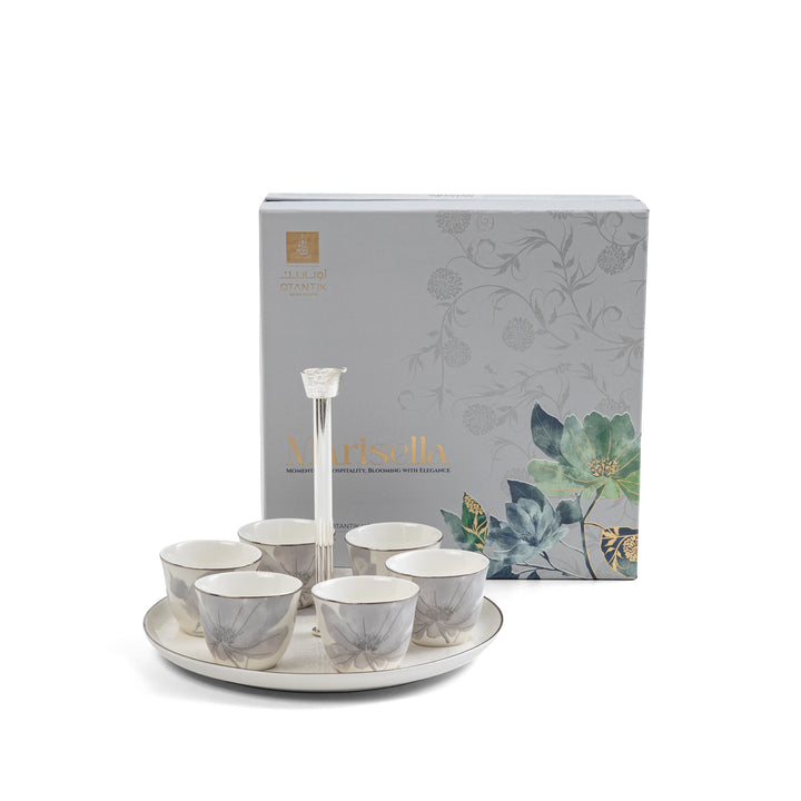 Set of tea cups and saucers with a decorative box on a white background