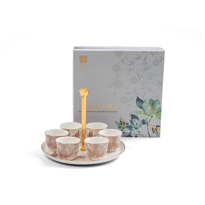 Set of ceramic cups with a gold handle on a white plate, next to a decorative box with floral designs.