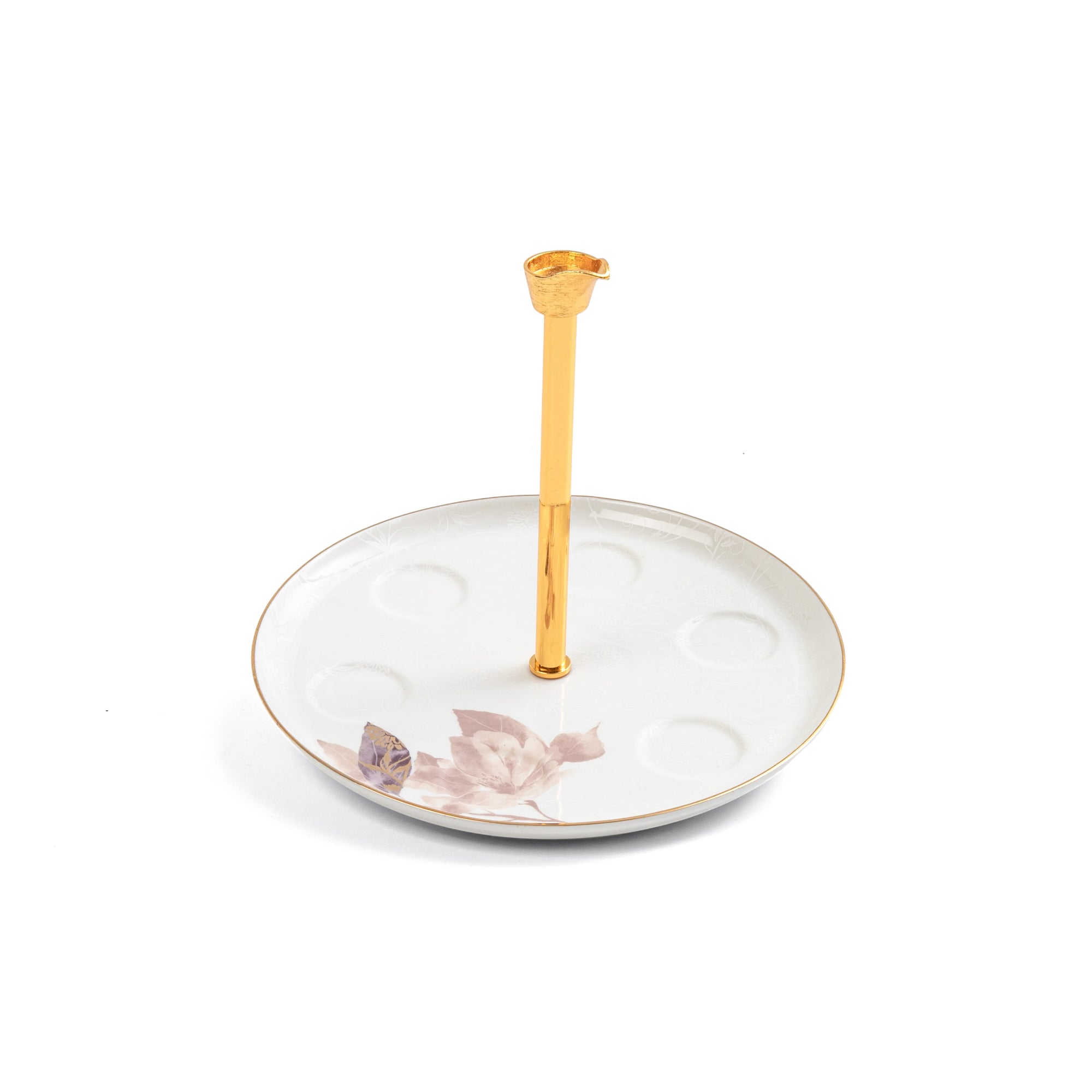 Decorative ceramic plate with floral design and a gold candle holder on a white background
