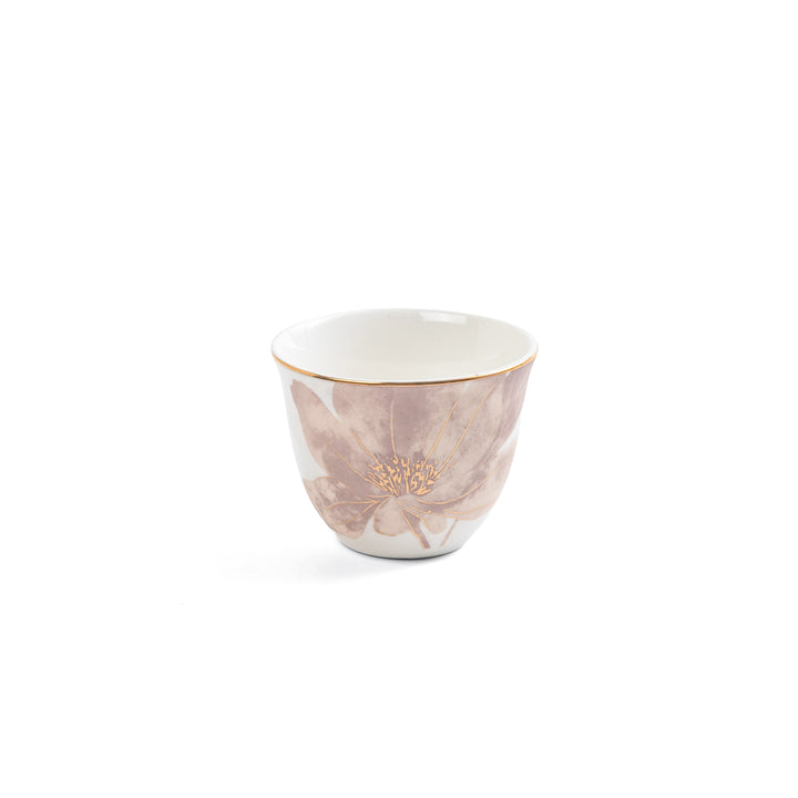White ceramic cup with floral design and gold rim on a white background