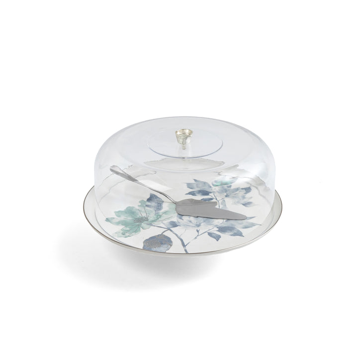 Clear cake stand with floral design and silver knife on a white background