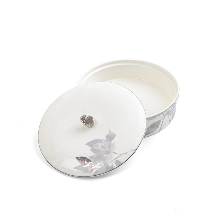 Round silver jewelry box with floral design on a white background