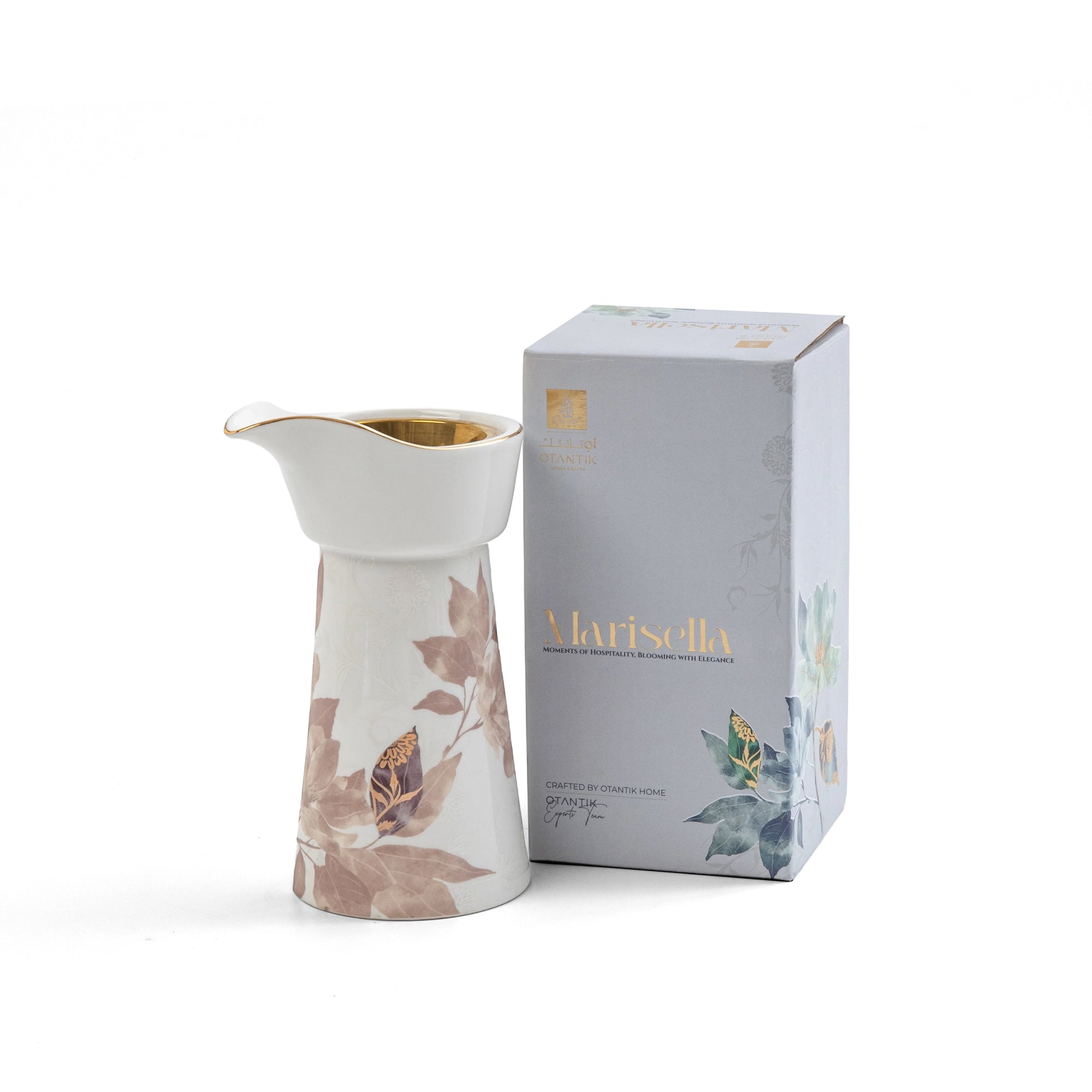 White ceramic pitcher with floral design next to a branded box on a white background