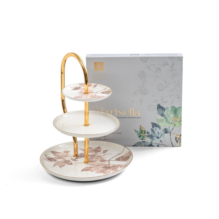 Three-tiered ceramic tray with gold accents in front of a 'Narisella' branded box.